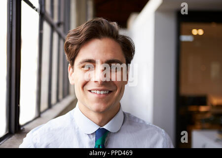Bianco giovane imprenditore sorridente alla telecamera, ritratto Foto Stock