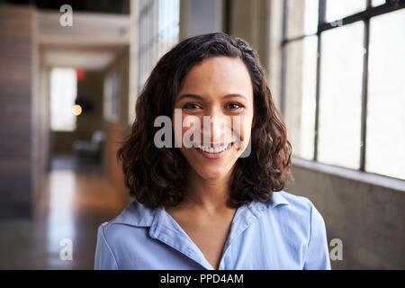 Giovani razza mista imprenditrice sorridente alla fotocamera Foto Stock