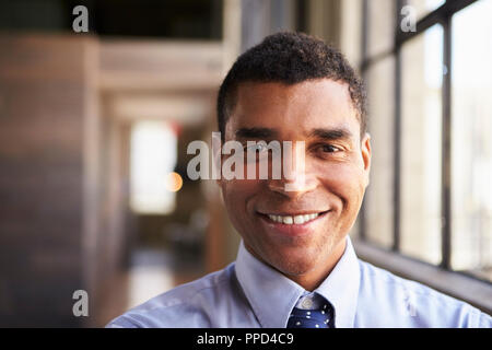 Close up ritratto di sorridere razza mista imprenditore Foto Stock