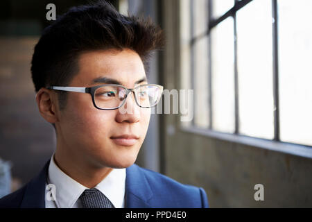 Giovane imprenditore asiatica guardando fuori della finestra, chiudere fino Foto Stock