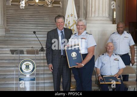 Un Coast Guard organo ausiliario mostra off una placca presentato a lei da Rhode Island Lt. Gov. Dan McKee Martedì, Settembre 4, 2018, presso lo State Capitol Building nella Provvidenza. La presentazione segue un annuncio da Rhode Island Gov. Gina Raimondo all'inizio dell'anno la designazione di Marzo 10, 2018 come guardacoste giorno ausiliario. (Coast Guard Foto Stock