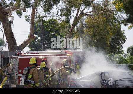 I vigili del fuoco estinguere un incendio su una vettura di masterizzazione a Downey, CA nel 2017 Foto Stock