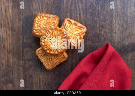 Torta della Luna Rossa e tovagliolo tessili sullo sfondo di legno Foto Stock