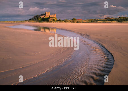 Tramonto al castello di Bamburgh, Bamburgh, Northumberland, England Regno Unito Foto Stock
