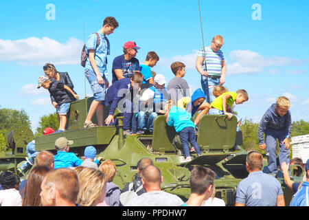 Ispezionare i bambini e giocare su un veicolo militare Foto Stock
