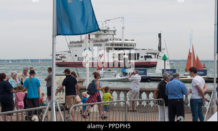 La gente sulla riva e traghetto per l'Isola di Wight visibile dietro il Solent, Cowes, Isle of Wight, Regno Unito Foto Stock