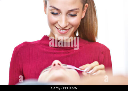 Donna adulta avente estensione ciglia professionale nel salone di bellezza Foto Stock