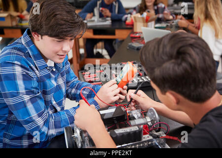 Due alunni maschi edificio veicolo robotico nella lezione di scienze Foto Stock