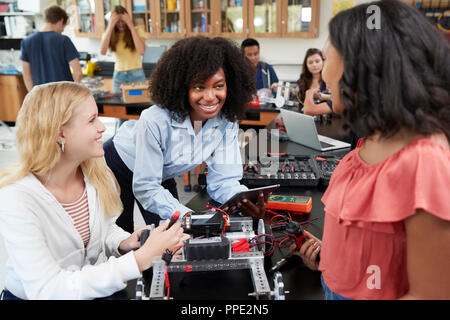 Insegnante con Allievi femminile costruzione veicolo robotico nella lezione di scienze Foto Stock