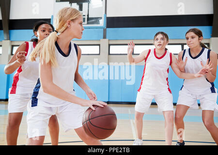 Femmina di alta scuola della squadra di basket ball dribbling sulla corte Foto Stock