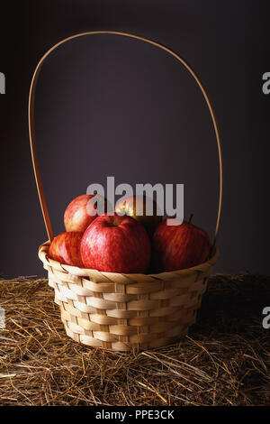 Mature mele rosse in un bel cesto di paglia di close-up Foto Stock