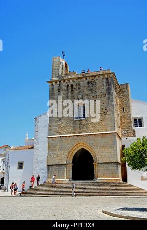 Vista della cattedrale di Faro in Praca Largo de Se nel centro della città con i turisti godendo l'impostazione, Faro, Algarve, Portogallo, dell'Europa. Foto Stock