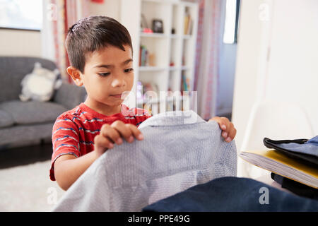 Ragazzo in camera da letto scegliendo Shirt pronto per la scuola Foto Stock
