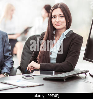 Ragioniere femmina funziona con i report finanziari alla sua scrivania. Foto Stock