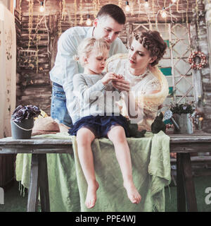 Bambina di cinque anni e di amare i genitori stanno considerando un regalo Foto Stock