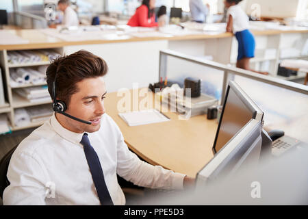 Maschio ispanica call center lavoratore a lavoro, vista in elevazione Foto Stock