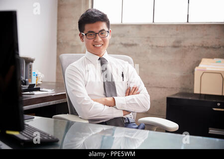 Giovane imprenditore asiatici presso un ufficio di accoglienza sorridente alla fotocamera Foto Stock