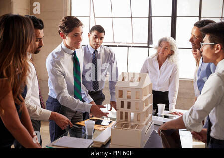 Architetti a discutere il modello in scala di un edificio Foto Stock
