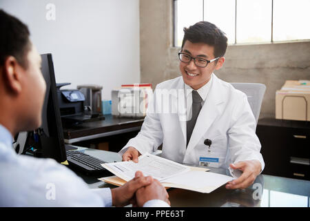 Felice asiatici medico maschio in consultazione con il paziente di sesso maschile Foto Stock