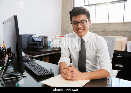 Giovani asiatici professionali maschio al ricevimento sorridente alla fotocamera Foto Stock