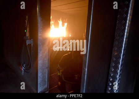 Firefighter studenti durante un esercizio in un simulatore di fuoco. Qui potete vedere il fuoco simulatore presso la stazione dei vigili del fuoco in Aidenbachstrasse a Monaco di Baviera. Foto Stock