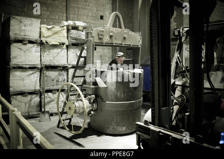 Lavoratore colata di un motore marino diesel. Foto Stock