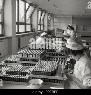 Degli anni Cinquanta, all'interno della fabbrica di Sandoz, Horsforth, Leeds, Inghilterra. La figura mostra i lavoratori di sesso femminile etichettare bottiglie dell'azienda prodotto Cafergot, un farmaco costituito da ergotamina tartrato e caffeina, usato per curare il mal di testa ed emicrania. Foto Stock