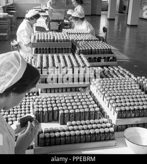 Degli anni Cinquanta, all'interno della fabbrica di Sandoz, Horsforth, Leeds, Inghilterra. La figura mostra i lavoratori di sesso femminile etichettare bottiglie dell'azienda prodotto Cafergot, un farmaco costituito da ergotamina tartrato e caffeina, usato per curare il mal di testa ed emicrania. Foto Stock