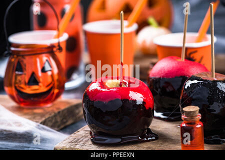 Caramella vetrato mele sulla festa di Halloween tabella. Foto Stock