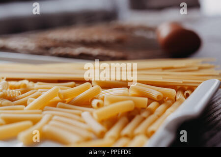 La pasta grezza sul legno rustico sfondo. Messa a fuoco selettiva Foto Stock