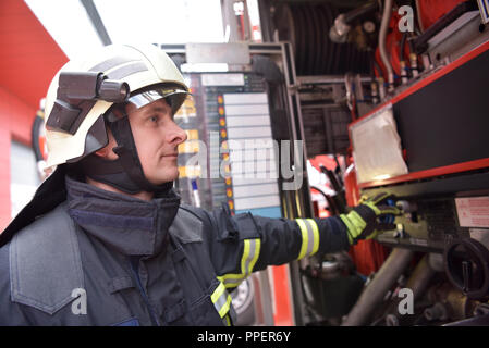 Ritratto di un vigile del fuoco nel centro di operazioni al veicolo antincendio Foto Stock