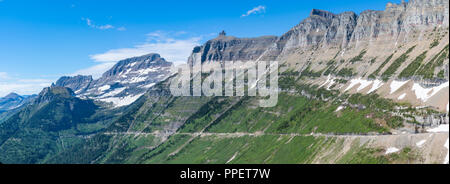 Andando al sole strada scavata nella montagna nel Parco Nazionale di Glacier, Montana Foto Stock