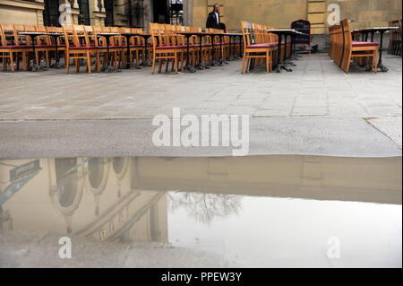 Sedie vuote sulla terrazza del Cafe Tambosi su Odeonsplatz in un giorno di pioggia in marzo. Foto Stock