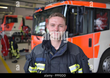 Ritratto di un vigile del fuoco nel centro di operazioni al veicolo antincendio Foto Stock