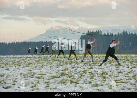 Il Weildorfer Schnalzer far schioccare la frusta prima dell'Untersberg. Un custom per espellere l'inverno nel Berchtesgadener Land, Alta Baviera, Germania Foto Stock