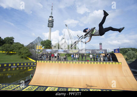 BMX trick a Tom Hawk visualizza durante il programma di apertura per la X-Games nell'Olympiapark a Monaco di Baviera. Sullo sfondo la torre olimpica. Foto Stock
