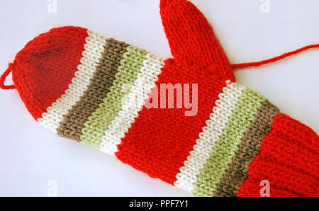 Luminose e colorate a mano a maglia mitten in rosso e verde e strisce bianche Foto Stock