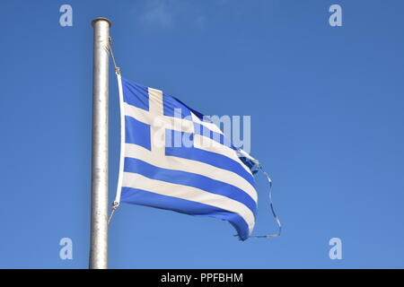 Grecia, la bellissima isola di iOS. La bandiera greca sventola con orgoglio nella brezza estiva, posta contro un cielo blu profondo. Foto Stock