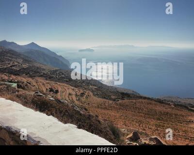 Grecia, l'isola remota e affascinante di Sikinos. Una splendida vista dalle alte montagne al mare Egeo sottostante, al tramonto in una giornata estiva Foto Stock