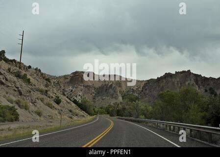 Una strada nel Wyoming passando attraverso colline Foto Stock