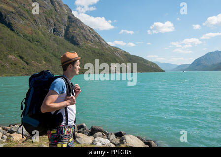 Escursionista con zaino guardando il lago Gjende nel Parco nazionale di Jotunheimen, Norvegia Foto Stock