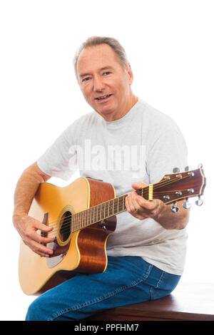 Verticale di inquadratura ravvicinata di un uomo maturo felicemente giocando la sua chitarra su uno sfondo bianco. Copia dello spazio. Foto Stock