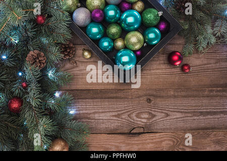 Vista superiore della bella baubles lucido e rametti di abete con pigne, sullo sfondo di Natale Foto Stock