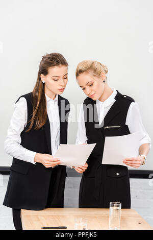 Felice giovani imprenditrici facendo documenti all ufficio moderno Foto Stock