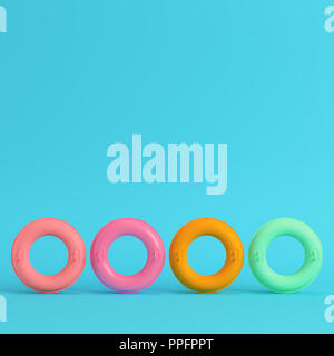 Quattro gonfiabili colorati anelli luminosi su sfondo blu in colori pastello. Concetto di minimalismo. 3D render Foto Stock