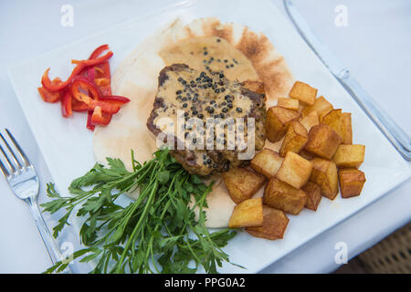 Primo piano dettaglio di filetto di manzo bistecca in salsa di pepe al ristorante di lusso con piscina all'aperto per impostazione rable Foto Stock