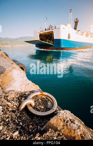 Grandi ferry boat con passeggeri e auto arriva bella isola greca. Vacanze estive Foto Stock