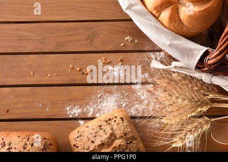 Fette di pane planked sulla tavola di legno in una cucina rustica. Composizione orizzontale. Vista superiore Foto Stock