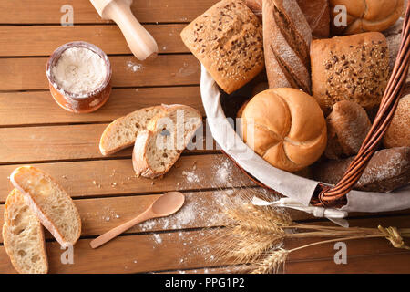 Fette di pane planked sulla tavola di legno in una cucina rustica. Composizione orizzontale. Vista superiore Foto Stock