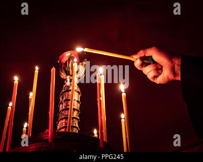 Dettaglio di una mano accendendo candele, l'immagine orizzontale Foto Stock